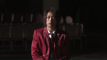 Movie still from “Love Exposure” (2008), directed by Sion Sono – A man in a red jacket is standing in the dark; Close Up shot, Low angle