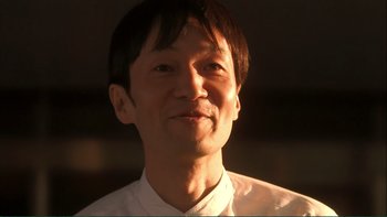 Movie still from “Love Exposure” (2008), directed by Sion Sono – A person wearing a white shirt; Close Up shot, Low angle