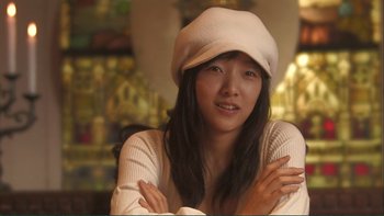 Movie still from “Love Exposure” (2008), directed by Sion Sono – A woman wearing a white hat posing for a picture; Close Up shot, Low angle