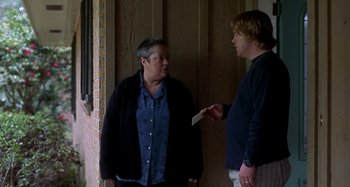 Movie still from “Love Liza” (2002), directed by Todd Louiso – A man and a woman standing next to each other; Medium shot, Over the shoulder angle