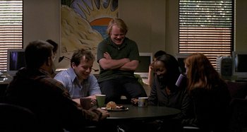 Movie still from “Love Liza” (2002), directed by Todd Louiso – A group of people sitting around a coffee table; Medium shot, Over the shoulder angle