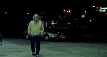 Movie still from “Love Liza” (2002), directed by Todd Louiso – A man walking down a street at night; Wide shot, Over the shoulder angle