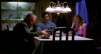Movie still from “Love Liza” (2002), directed by Todd Louiso – A group of people sitting at a dinner table; Medium shot, Over the shoulder angle