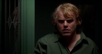 Movie still from “Love Liza” (2002), directed by Todd Louiso – A man with blonde hair and a green shirt looking to his left; Close Up shot, Over the shoulder angle