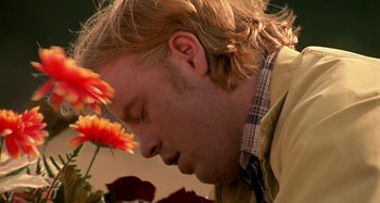 Movie still from “Love Liza” (2002), directed by Todd Louiso – A person smelling a flower; Close Up shot, Low angle