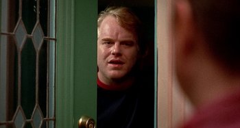Movie still from “Love Liza” (2002), directed by Todd Louiso – A person standing in a door way; Close Up shot, Over the shoulder angle
