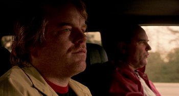 Movie still from “Love Liza” (2002), directed by Todd Louiso – A man sitting next to another man in the back of a car; Close Up shot, Over the shoulder angle