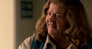 Movie still from “Love Liza” (2002), directed by Todd Louiso – An older woman with long brown hair smiling; Close Up shot, Over the shoulder angle