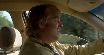 Movie still from “Love Liza” (2002), directed by Todd Louiso – A man in a yellow jacket driving in a car; Close Up shot, Over the shoulder angle