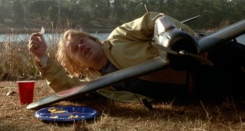 Movie still from “Love Liza” (2002), directed by Todd Louiso – A man laying on the ground in the grass; Medium shot, Low angle