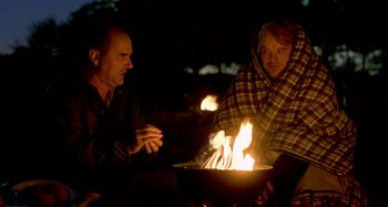 Movie still from “Love Liza” (2002), directed by Todd Louiso – Two men sitting around a fire at night; Medium shot, Over the shoulder angle