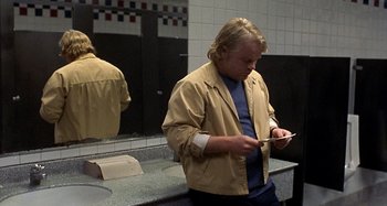 Movie still from “Love Liza” (2002), directed by Todd Louiso – A man standing in front of a bathroom mirror; Medium shot, Over the shoulder angle