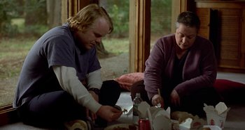 Movie still from “Love Liza” (2002), directed by Todd Louiso – A man and a woman sitting at a table eating food; Medium shot, High angle