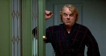 Movie still from “Love Liza” (2002), directed by Todd Louiso – A man standing in front of a green door; Medium shot, Over the shoulder angle