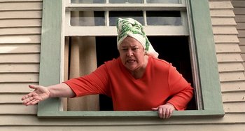 Movie still from “Love Liza” (2002), directed by Todd Louiso – An older woman wearing a head scarf looking out of a window; Medium shot, Low angle