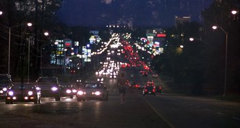 Movie still from “Love Liza” (2002), directed by Todd Louiso – A city street filled with lots of traffic at night; Extreme Wide shot, High angle
