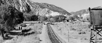 Movie still from “Love Me Tender” (1956), directed by Robert D. Webb – A train track in the middle of the desert with mountains in the background; Extreme Wide shot, High angle
