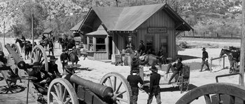 Movie still from “Love Me Tender” (1956), directed by Robert D. Webb – A black and white photo of a town with a horse drawn carriage; Extreme Wide shot, High angle
