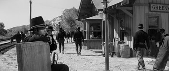Movie still from “Love Me Tender” (1956), directed by Robert D. Webb – A black and white photo of a group of men walking down a dirt road; Wide shot, Over the shoulder angle