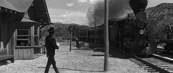 Movie still from “Love Me Tender” (1956), directed by Robert D. Webb – A man walking on the side of a train track next to a train; Wide shot, Low angle