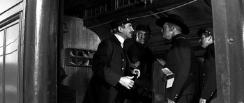 Movie still from “Love Me Tender” (1956), directed by Robert D. Webb – A group of men standing next to each other in a room; Medium shot, Low angle