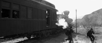 Movie still from “Love Me Tender” (1956), directed by Robert D. Webb – A man walking on a train track next to a train; Wide shot, High angle