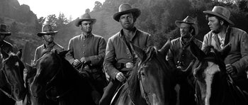 Movie still from “Love Me Tender” (1956), directed by Robert D. Webb – A black and white photo of men on horses; Medium shot, Low angle