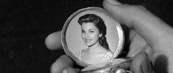 Movie still from “Love Me Tender” (1956), directed by Robert D. Webb – An old photo of a woman in a circle; Extreme Close Up shot, Overhead angle