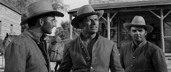 Movie still from “Love Me Tender” (1956), directed by Robert D. Webb – A black and white photo of a man wearing a cowboy hat; Medium shot, Over the shoulder angle
