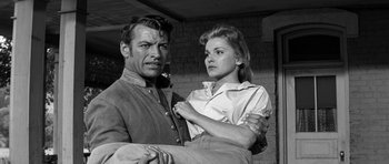 Movie still from “Love Me Tender” (1956), directed by Robert D. Webb – A man and a woman standing next to each other; Medium shot, Low angle