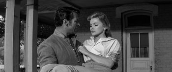 Movie still from “Love Me Tender” (1956), directed by Robert D. Webb – A man and a woman are holding each other; Medium shot, Low angle