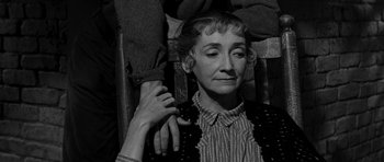 Movie still from “Love Me Tender” (1956), directed by Robert D. Webb – An older woman sitting in a chair with a hand on her shoulder; Close Up shot, Over the shoulder angle