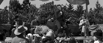 Movie still from “Love Me Tender” (1956), directed by Robert D. Webb – A black - and - white photo of a man on a stage; Wide shot, Low angle