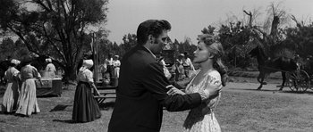 Movie still from “Love Me Tender” (1956), directed by Robert D. Webb – A man and a woman dancing in an outdoor setting; Medium shot, Over the shoulder angle