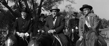 Movie still from “Love Me Tender” (1956), directed by Robert D. Webb – A group of men riding horses on a field; Medium shot, Low angle