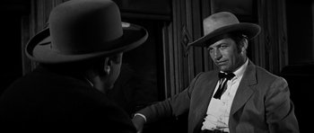 Movie still from “Love Me Tender” (1956), directed by Robert D. Webb – A black and white photo of a man shaking hands with another man; Close Up shot, Over the shoulder angle