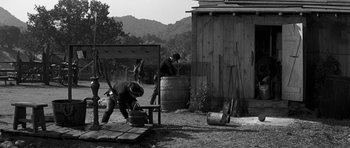 Movie still from “Love Me Tender” (1956), directed by Robert D. Webb – A black - and - white photo of people working in a field; Wide shot, High angle