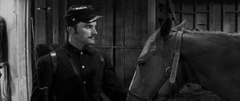 Movie still from “Love Me Tender” (1956), directed by Robert D. Webb – A black and white photo of a man and a horse; Close Up shot, Over the shoulder angle