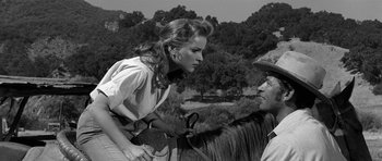 Movie still from “Love Me Tender” (1956), directed by Robert D. Webb – A man and a woman on a horse in a black and white photo; Medium shot, Over the shoulder angle