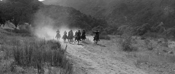 Movie still from “Love Me Tender” (1956), directed by Robert D. Webb – A black and white photo of a group of people riding horses; Extreme Wide shot, Low angle