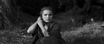Movie still from “Love Me Tender” (1956), directed by Robert D. Webb – A woman wrapped in a blanket sitting in the grass; Close Up shot, Low angle