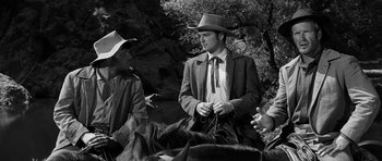 Movie still from “Love Me Tender” (1956), directed by Robert D. Webb – A black and white photo of a man in a cowboy hat; Medium shot, Over the shoulder angle