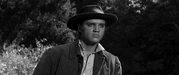 Movie still from “Love Me Tender” (1956), directed by Robert D. Webb – A black and white photo of a man wearing a hat; Close Up shot, Low angle