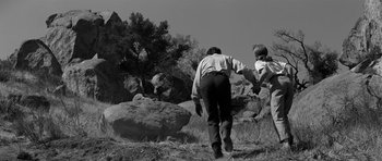 Movie still from “Love Me Tender” (1956), directed by Robert D. Webb – A man and a child are walking through the grass; Wide shot, Low angle