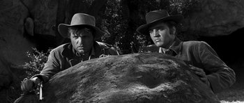 Movie still from “Love Me Tender” (1956), directed by Robert D. Webb – A black and white photo of two men standing next to each other; Medium shot, Low angle