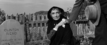 Movie still from “Love Me Tender” (1956), directed by Robert D. Webb – An older woman holding a white piece of paper; Medium shot, Over the shoulder angle