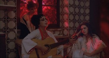 A woman playing an instrument while sitting on a chair