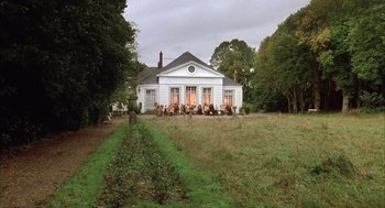 Movie still from “Love and Death” (1975), directed by Woody Allen – A large white building with a lot of people sitting outside; Extreme Wide shot, High angle