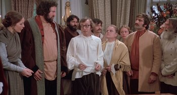 Movie still from “Love and Death” (1975), directed by Woody Allen – A group of people standing in a room; Medium shot, High angle