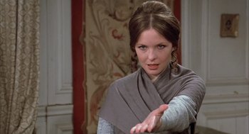 Movie still from “Love and Death” (1975), directed by Woody Allen – A young woman in a gray scarf is holding her hand out; Close Up shot, Over the shoulder angle